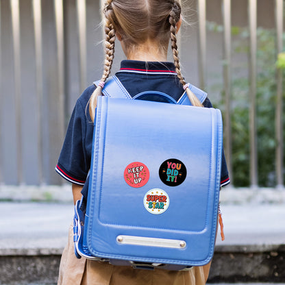 Child wearing a blue backpack with colorful Encouraging Sticker – Classroom Praise Design stickers outdoors