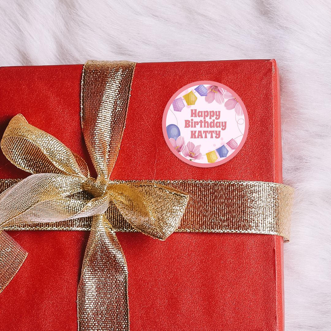 Red gift box with gold ribbon and 'Happy Birthday Katty'   custom circle stickers on a white background