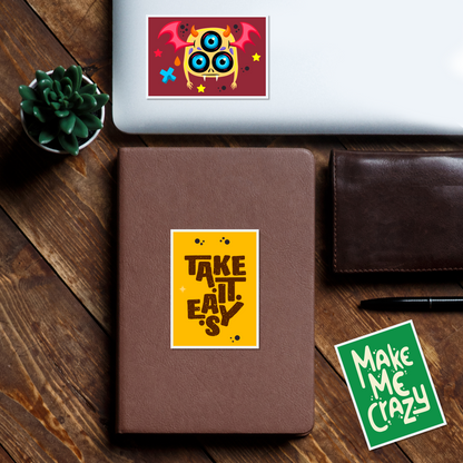 Notebook with a rectangle stickers on a wooden surface, featuring a colorful owl illustration and text.